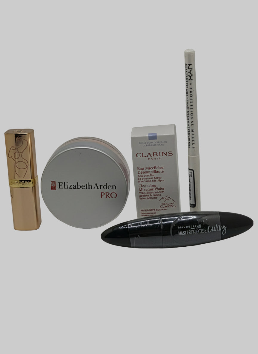 Collection of cosmetic products including a lipstick, cream, and a tube on a gray background