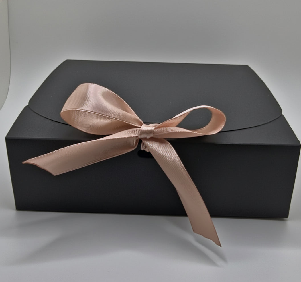 Black gift box with a pink ribbon on a white background