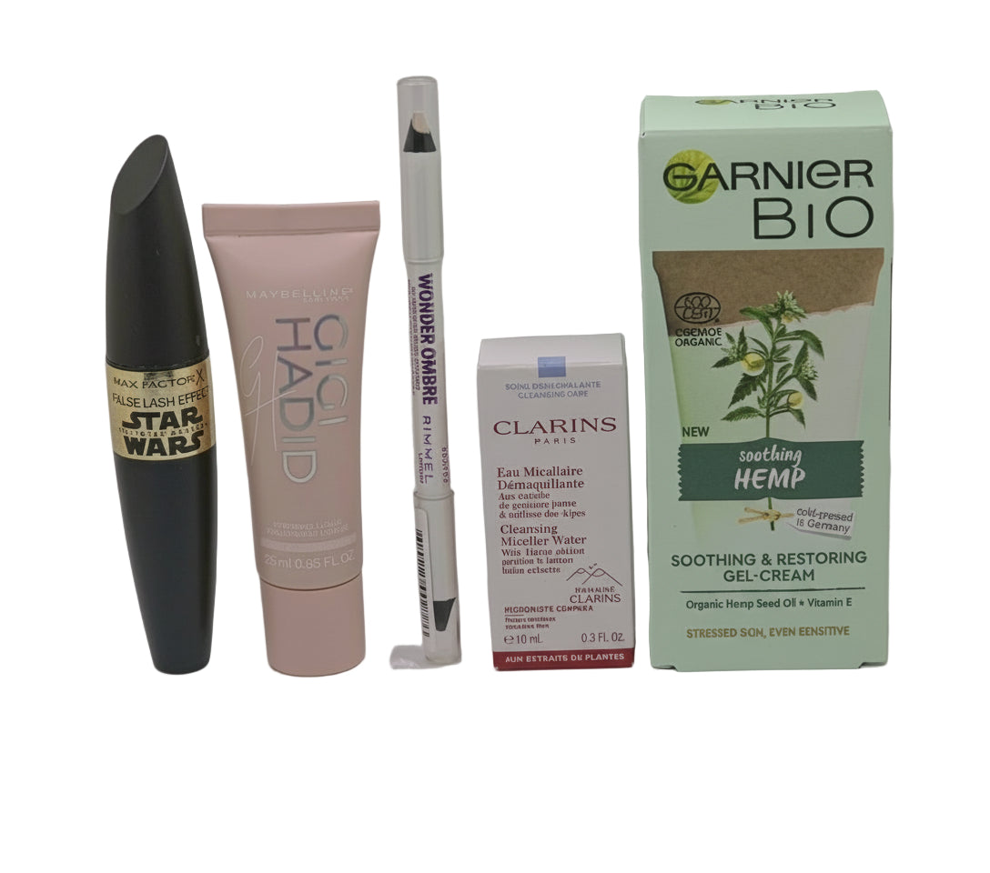 Collection of cosmetic products including a mascara, lip balm, and skincare items on a gray background