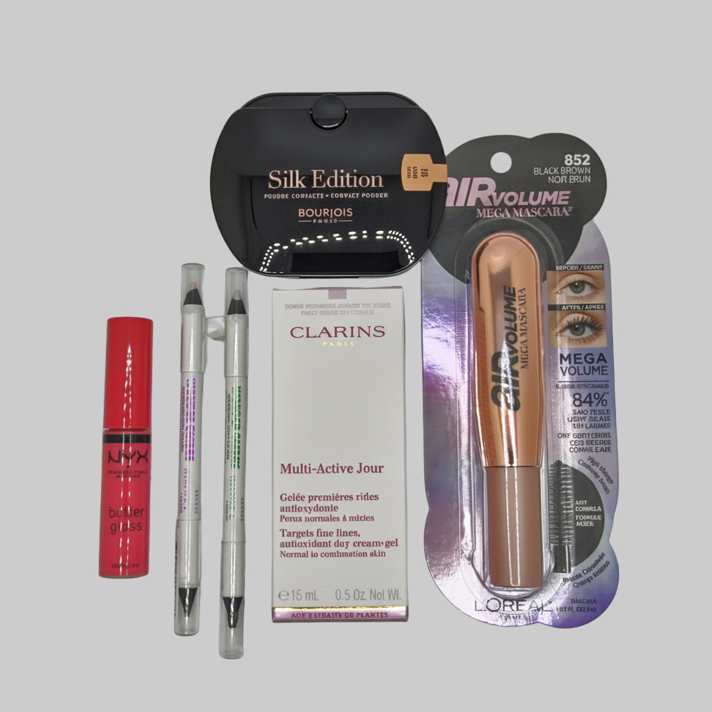 Collection of makeup products including a red lipstick, two pens, a Clarins box, and a L'Oreal mascara on a gray background.